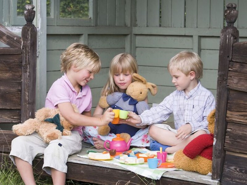 Photo image of children outside having a teddy bear picnic (Shutterstock image)