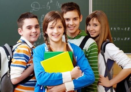 Photo image of four school teenagers standing in a classroom looking directly into the camera (Freepik image)