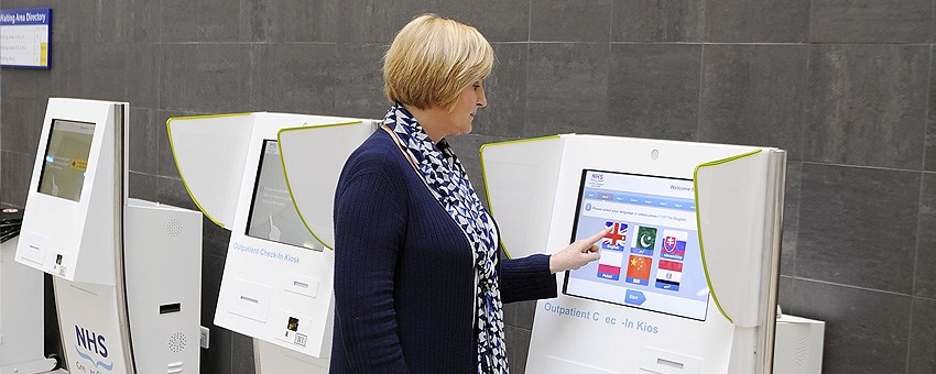 Female using self check-in at the QEUH