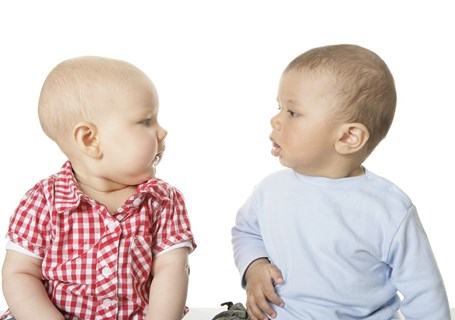Photo image of two babies sitting down appearing to talk to each other (Pixabay image)