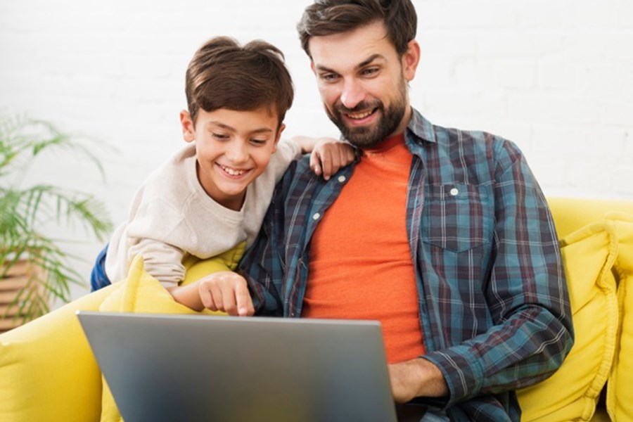 Photo image of a child and adult looking at a laptop together (Freepik image)