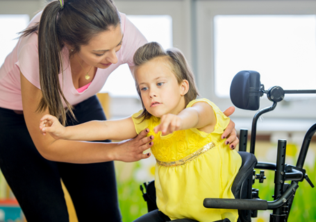 Photo image of an adult helping a child in a specialist seat to stand up (Canva image)
