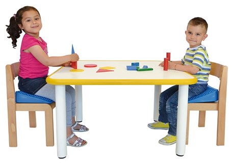 Photo image of two children sitting at a table playing with a construction toy